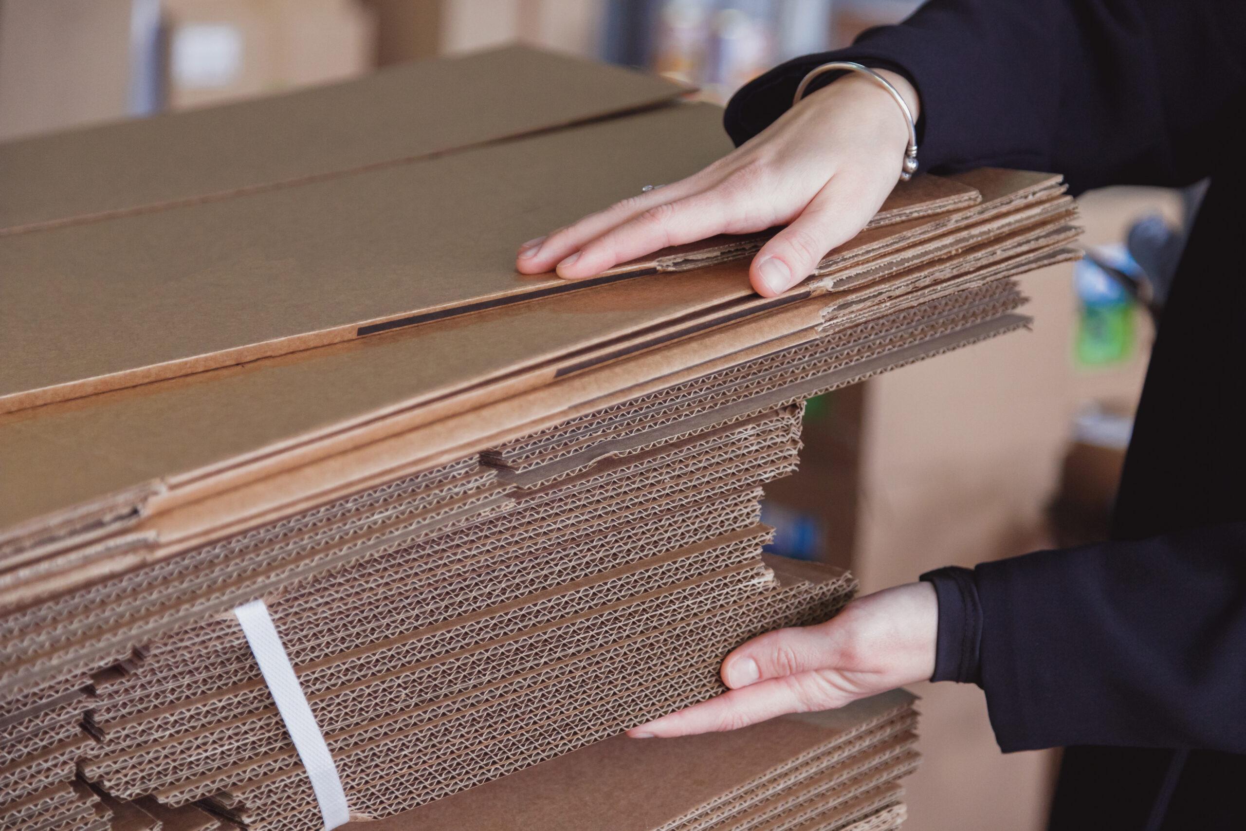 woman taking folded stacks of corrugated cardboard 2023 11 27 05 13 14 utc scaled Clayton Industries – Advanced Steam Boiler Technology